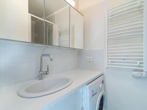 uma casa de banho branca com um lavatório e uma máquina de lavar roupa em Studio Les Pistes - Lavachet-4 by Interhome em Tignes