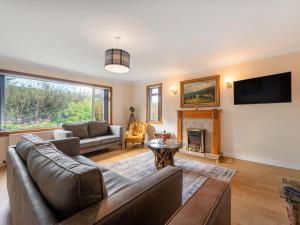 a living room with a couch and a fireplace at Holiday Home Birnam by Interhome in Drumnadrochit