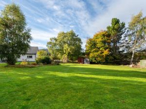 a large yard with a house and trees at Holiday Home Birnam by Interhome in Drumnadrochit
