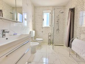 y baño blanco con aseo y ducha. en Holiday Home Lugema by Interhome en Labin