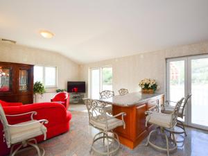 a living room with a red couch and a table at Holiday Home Villa Kursar by Interhome in Zaton