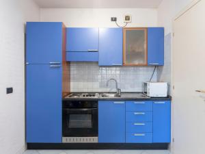 a kitchen with blue cabinets and a refrigerator at Apartment Acqua marina by Interhome in Sanremo