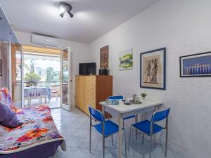 a living room with a table and blue chairs at Apartment Acqua marina by Interhome in Sanremo
