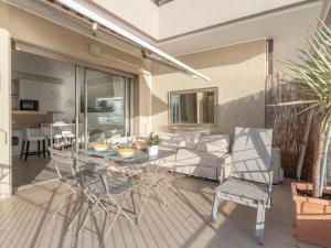 um pátio com uma mesa, cadeiras e um sofá em Apartment Mare Azzurro by Interhome em Ventimiglia