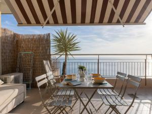 uma sala de estar com uma mesa e cadeiras numa varanda em Apartment Mare Azzurro by Interhome em Ventimiglia