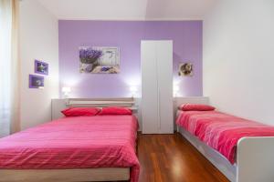 2 Betten in einem Zimmer mit lila und weißen Wänden in der Unterkunft Panacea in Salerno