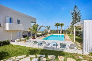 uma piscina com cadeiras e uma casa em Villa Ciuridda em Alcamo Marina