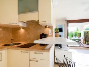 eine Küche mit weißen Schränken und einem Waschbecken in der Unterkunft Apartment Les Balcons de l'Atlantique-16 by Interhome in Vaux-sur-Mer