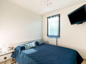 Schlafzimmer mit einem blauen Bett und einem Flachbild-TV in der Unterkunft Apartment Les Balcons de l'Atlantique-16 by Interhome in Vaux-sur-Mer
