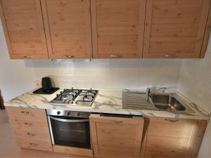 una cucina con piano cottura e lavandino di Apartment Albergo Diffuso - Cjasa de Pagnocca-2 by Interhome a Barcis