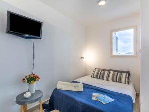una piccola camera con letto e TV a parete di Apartment Le Panama-5 by Interhome a Saint-Aygulf