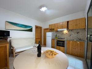 a kitchen with a table with a bottle of wine at Apartment Green House by Interhome in La Caletta
