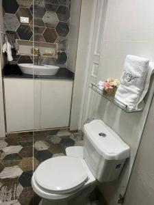 een badkamer met een wit toilet en een wastafel bij Hermosa villa en Jarabacoa in Jarabacoa