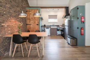 cocina y comedor con mesa de madera y sillas en In de 7e Hemel, en Grashoek