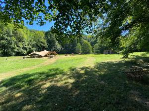 a grass field with a tent in the background at Domaine du Moulin in Mouzieys-Teulet