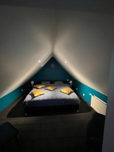 Una cama con almohadas amarillas en una habitación oscura en Le Wellness Privatif, en Seraing