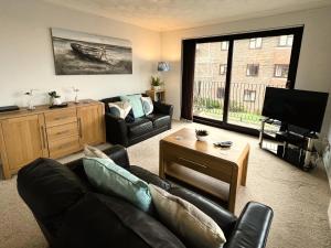 a living room with a couch and a tv at Brunswick Court in Cowes