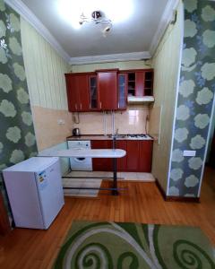 a small kitchen with wooden cabinets and a white refrigerator at New Build Apartment On Argishti Street in Yerevan