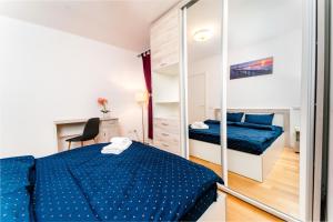 um quarto com uma cama azul e um espelho em Central 700 square Fructus plaza - Eva apartment em Timisoara