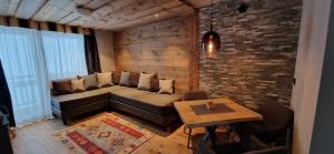 uma sala de estar com um sofá e uma mesa em La Roccia Wellness Hotel em Cavalese