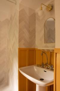 a bathroom with a sink and a mirror at La Maison Maroc in Les Dubois