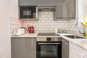 a kitchen with a stove and a sink at Great Mayfair London Flat in London