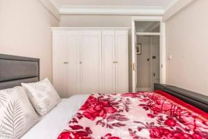 a bedroom with a bed with a red and white blanket at Great Mayfair London Flat in London