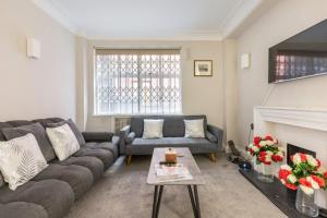 a living room with a couch and a fireplace at Great Mayfair London Flat in London