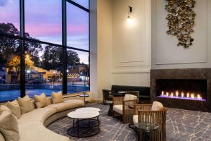 a lobby with a fireplace and a couch and chairs at Hyatt Regency Morristown in Morristown