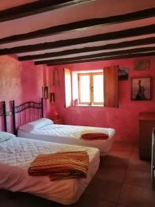 two beds in a room with pink walls at Villa Parra in Benissa