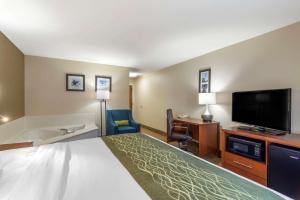a hotel room with a bed and a flat screen tv at Comfort Inn & Suites - near Robins Air Force Base Main Gate in Warner Robins