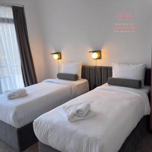 duas camas num quarto de hotel com toalhas em LAKEVIEW Hotel & Apartments em Mavrovo