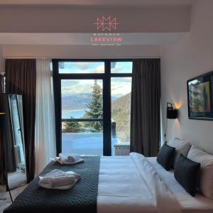 a bedroom with a large bed with a large window at LAKEVIEW Hotel & Apartments in Mavrovo