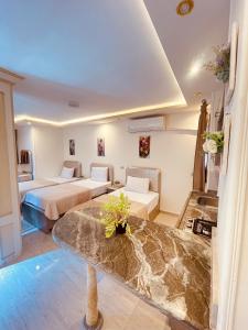 Cette chambre comprend 2 lits et une table. dans l'établissement El mansour hotel apartmen 93, à Mansoura