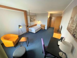 Habitación de hotel con cama, mesa y sillas en Best Western Parkhotel Brehna-Halle, en Brehna
