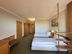 a hotel room with three beds in it at Best Western Parkhotel Brehna-Halle in Brehna