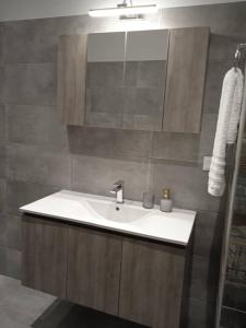 bagno con lavandino e specchio di Spiridoula Luxury Villa a Roda
