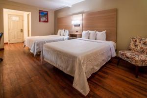 una habitación de hotel con 2 camas y una silla en Quality Inn Bishop near Mammoth en Bishop