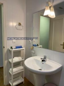 Baño blanco con lavabo y espejo en MyChoice Costa Atlántica by Bossh Apartments, en Rota