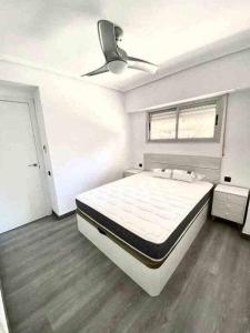 1 dormitorio con 1 cama grande y ventilador de techo en Apartamento en la playa Els Terrers, en Benicàssim
