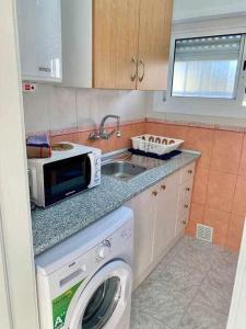 cocina con lavadora y microondas en Apartamento en la playa Els Terrers, en Benicàssim