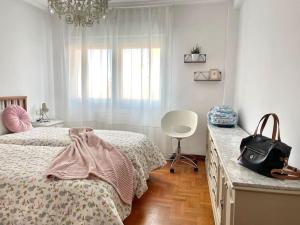 - une chambre avec un lit, une commode et une chaise dans l'établissement 167A La Costa de mis amores, à Gijón