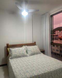 una camera con letto, ventilatore a soffitto e finestra di Loft Prainha ad Arraial do Cabo