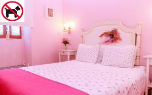 Dormitorio rosa con cama blanca con sábanas rosas en Casa da Tita, en Salir