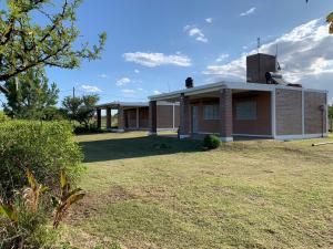 a house with a grass yard in front of it at Cabañas El Descanso in Potrero de Garay