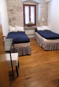 Una habitación con dos camas y una mesa y una ventana. en Pearl of Povlja, en Povlja