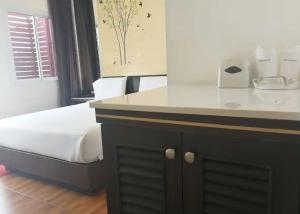 a bedroom with a bed and a white counter top at The Ring Khokmao Hotel 
