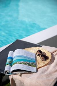 a book and sunglasses sitting on a table next to a pool at Villa Casilla de Costa Private Pool Luxury La Oliva By Holidays Home in La Oliva