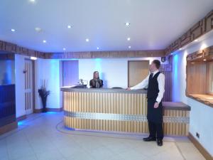 a man standing at a bar in a hotel lobby at The President Hotel in Blackpool