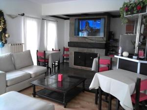 sala de estar con sofá, mesa y TV en Wanglen Hotel en Ostende